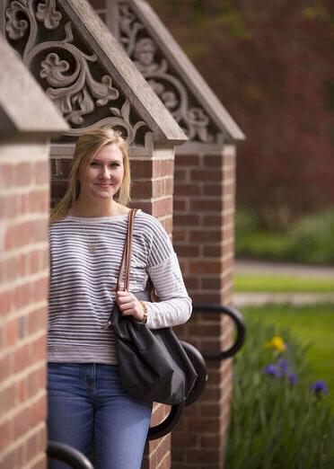 A student poses alongside a building